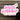 Pink 'con amor' sign with 'Pampering Studio' text on a wooden background